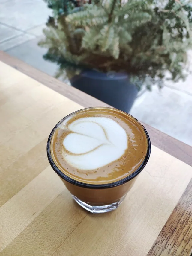 Cortado with latte art on a bright table