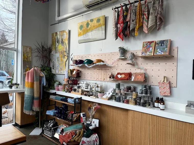 Retail wall with local goods, plants, and art inside Press Cafe
